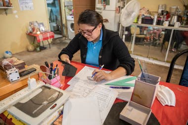 The kitchen-living-dining room of Angeles' house is now also a classroom; he teaches Mathematics and has 30 students per course; most of the inquiries come via WhatsApp.