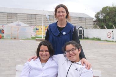 Claudia with the students Camila (today in 6th year) and Lourdes (who graduated this year), when LA NACION traveled to learn about the biodigester project