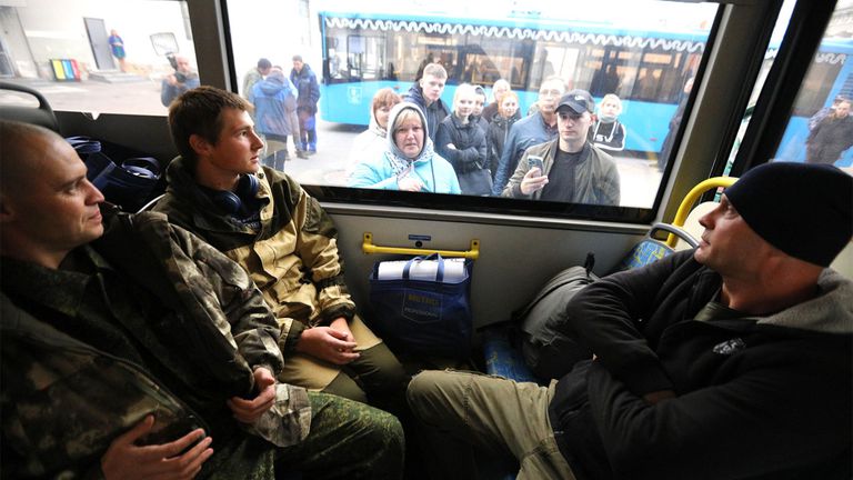 Hombres reclutados para la guerra en Moscú son trasladados en un vehículo.