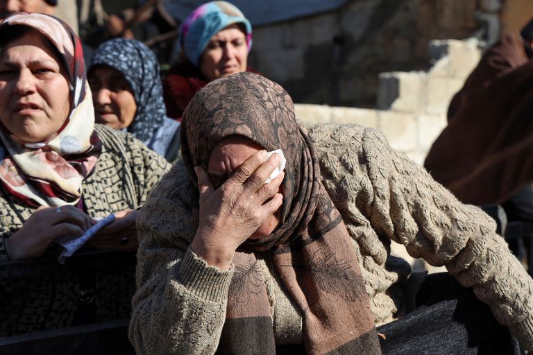 Mulheres sírias choram ao lado de corpos deitados na traseira de um caminhão em 7 de fevereiro de 2023, na cidade de Jandaris, na Síria, na parte controlada pelos rebeldes da província de Aleppo, enquanto a operação de busca continua após um terremoto mortal.